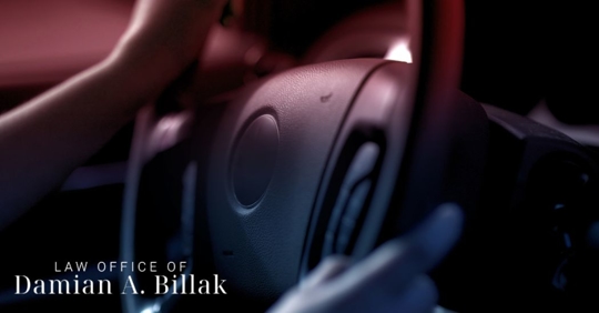 closeup of a steering wheel with police lights shining in the car